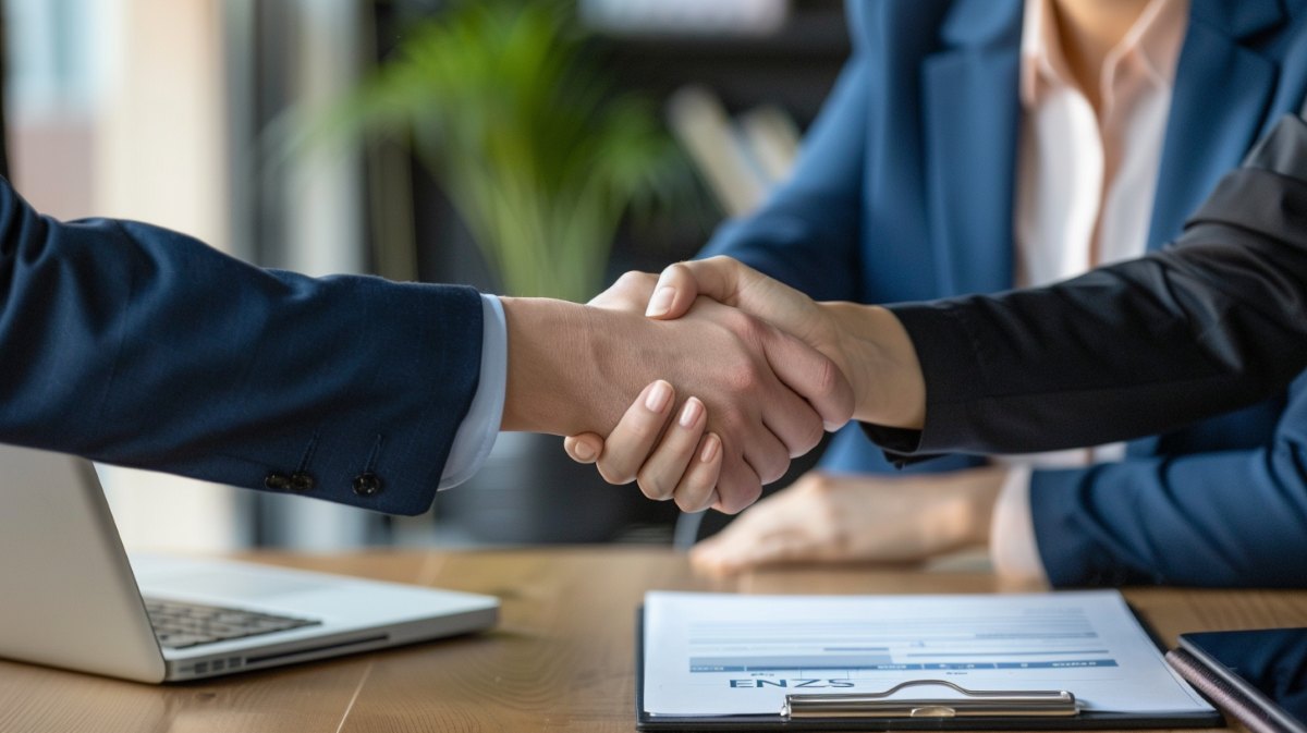 Homeowner and contractor shake hands over contract in a modern office, confirming replacement windows Saratoga, CA.
